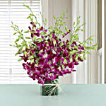 Exotic Expression - Arrangement of 20 purple orchids in glass vase.